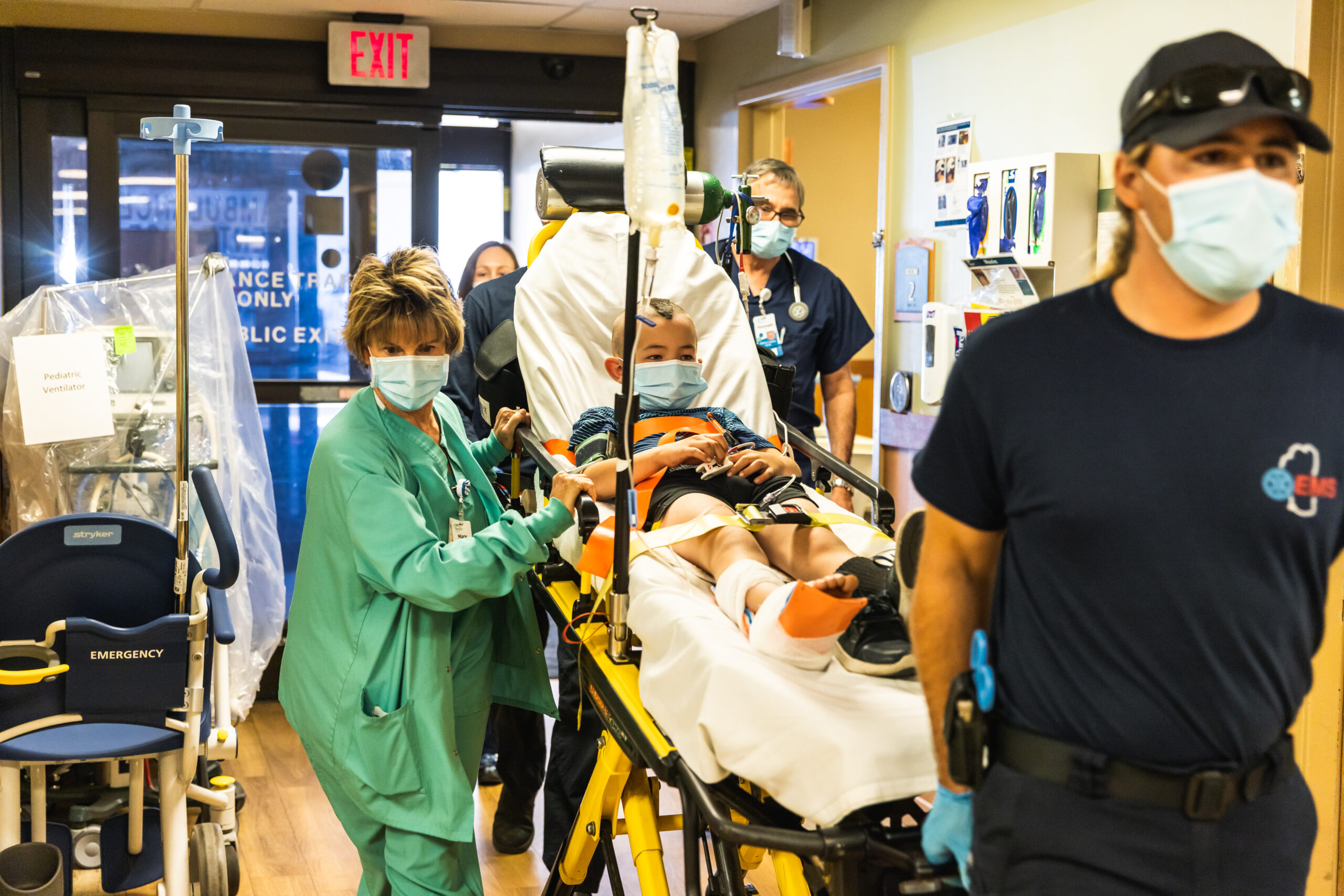 EMTs and nurses rushing someone into a hospital on a gurney