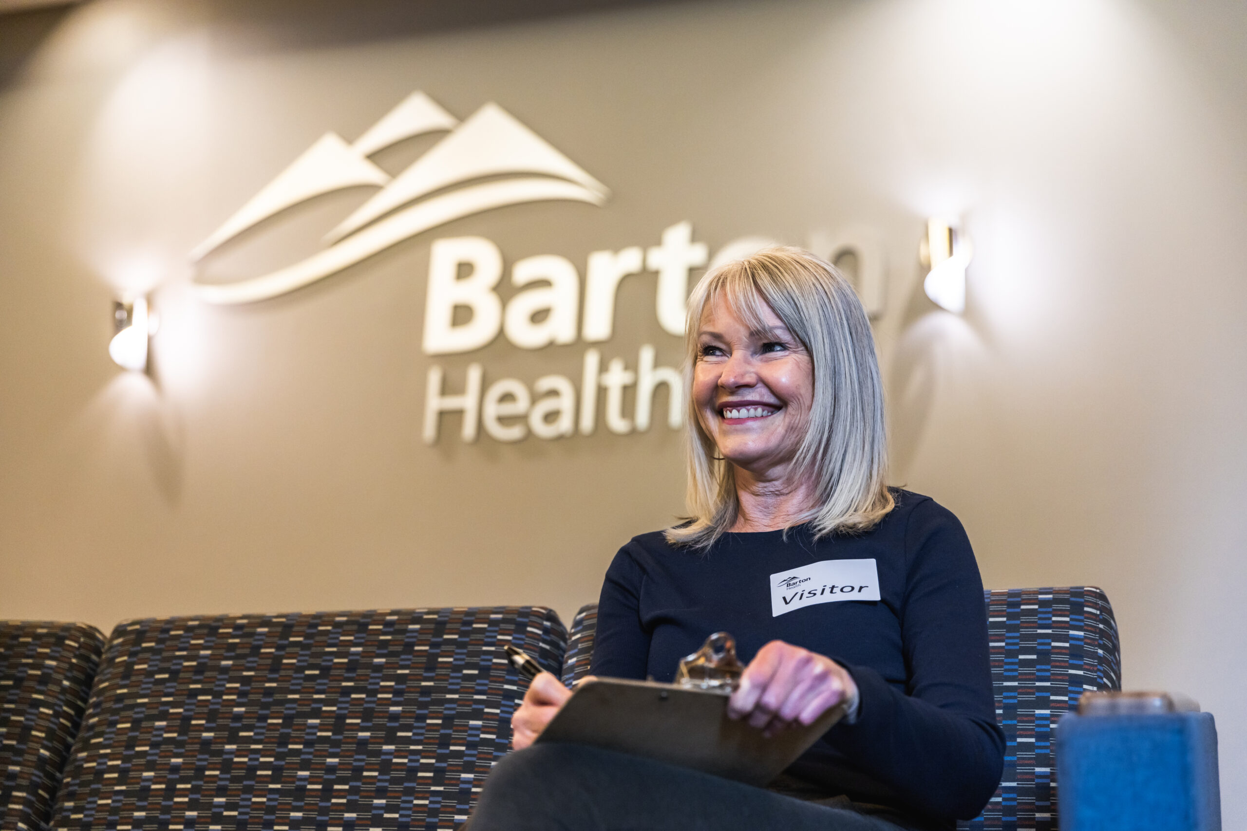 Woman smiling in front of Barton sign