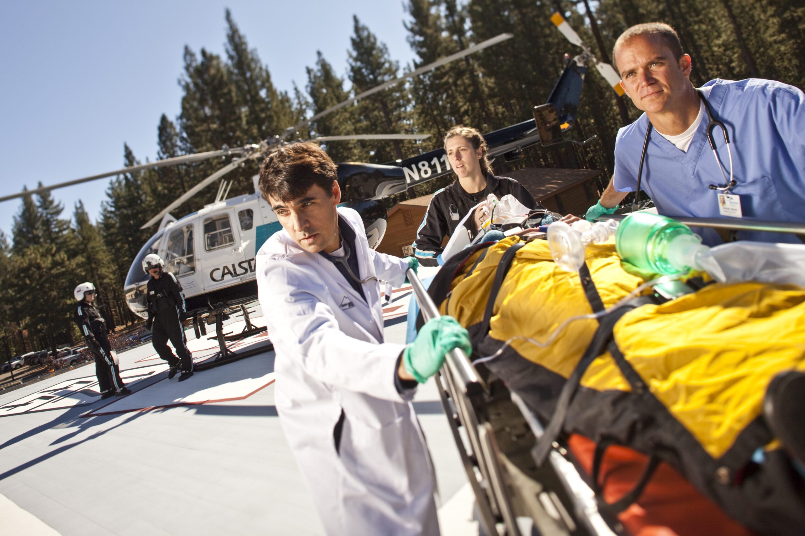Nurses and doctors surrounding a gurney with a helicopter in the back