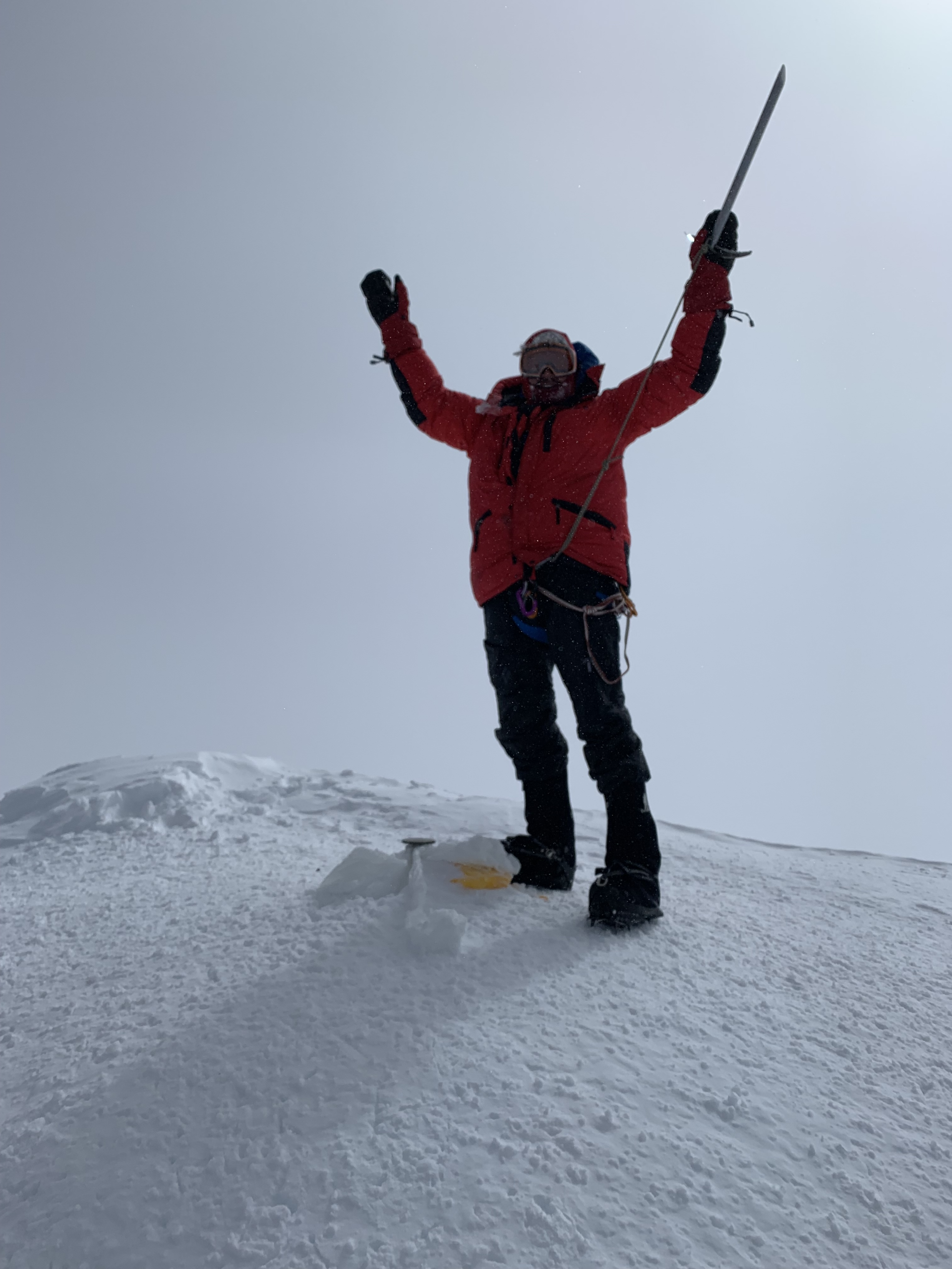 Dr. Habicht stands on top of a mountain peak.